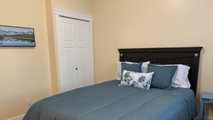 A bedroom with a bed, a headboard, and a nightstand. - Kate's Cove in North Nanaimo - quiet location, 5 minute walk to ocean (Nanaimo)