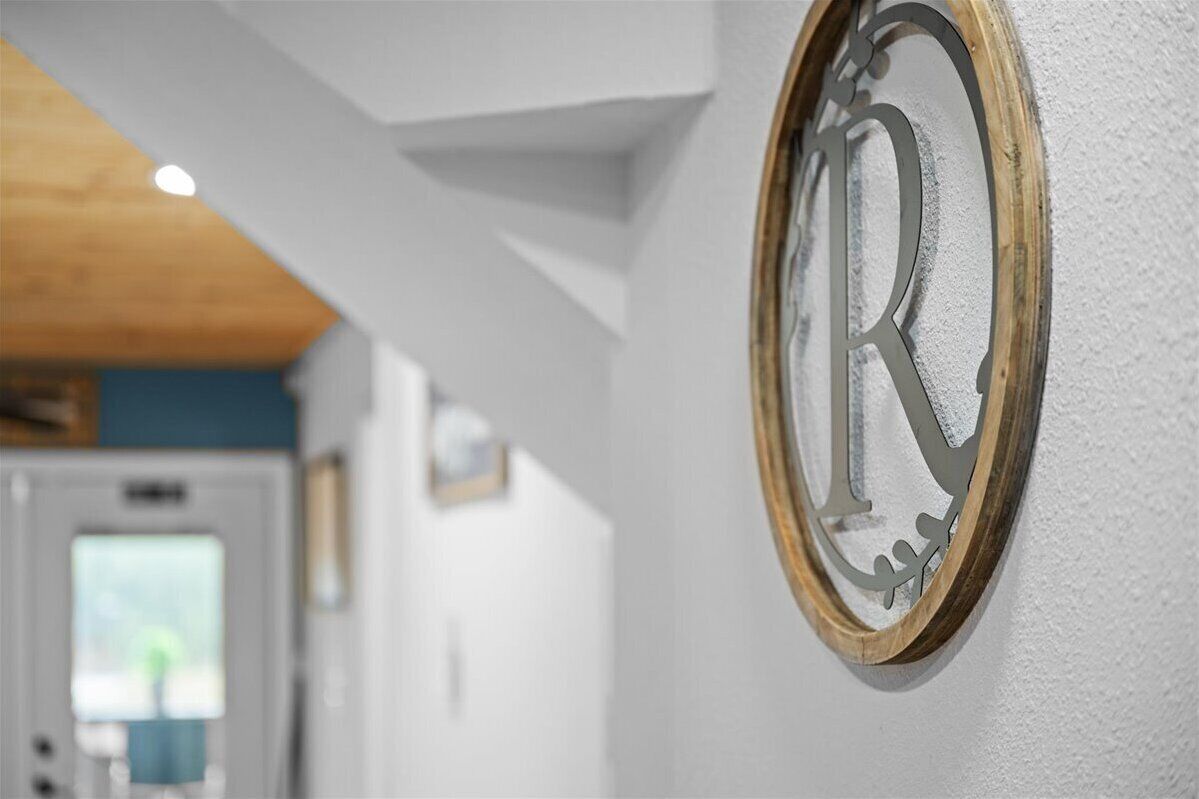 Ein detailreiches Foto von einem hölzernen Rahmen um den Buchstaben 'R' an einer Wand.