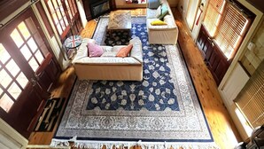 A cozy attic room with a fireplace, two sofas, a coffee table, and a patterned rug. - Gingerbread House – sunset, relaxing & warm (Katoomba)