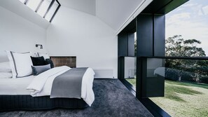 Une chambre moderne avec un grand lit, une vue sur l’extérieur et une fenêtre de toit.