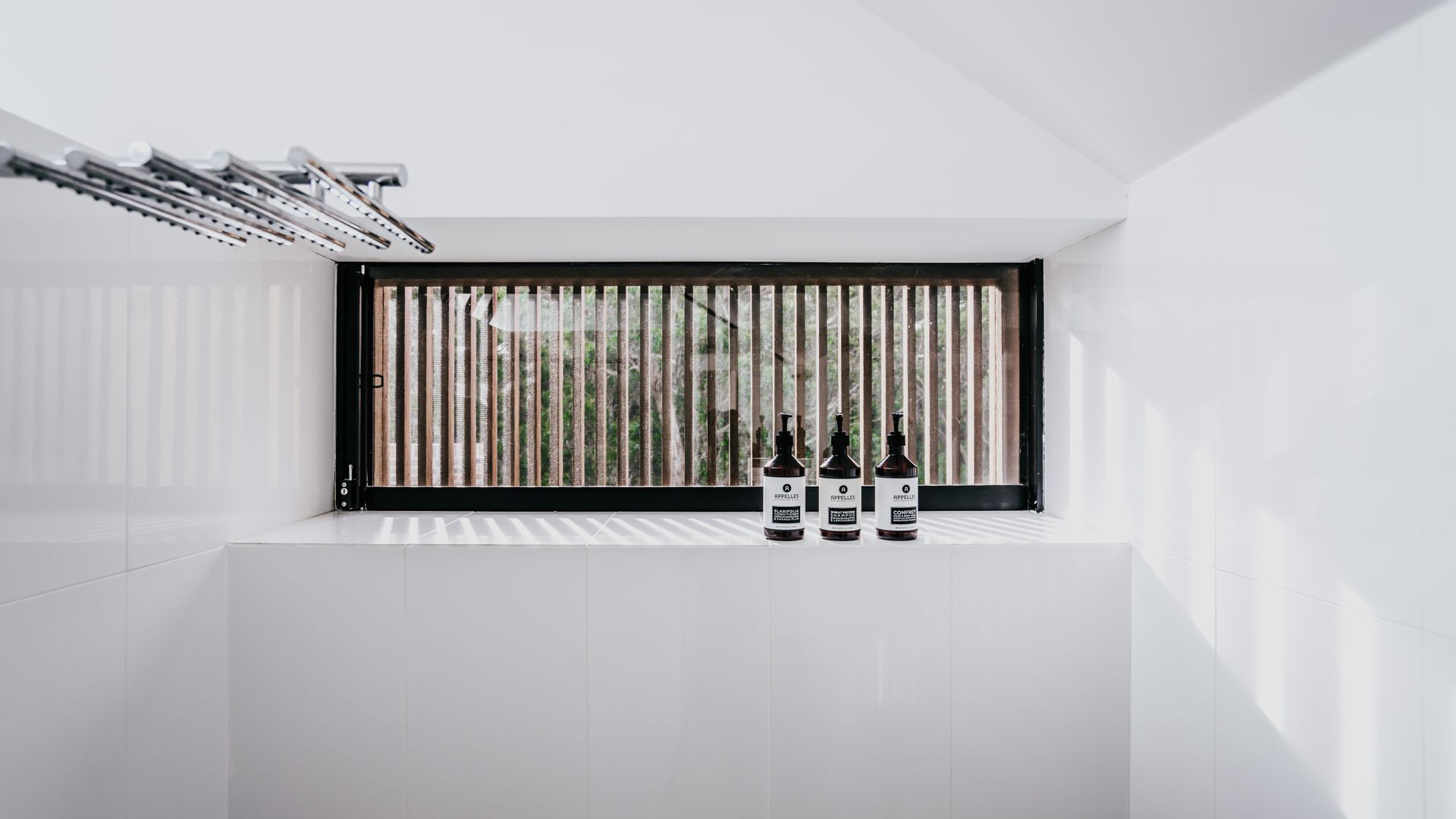 Ein modernes Badezimmer mit großem Fenster, weißen Wänden und einem Handtuchhalter.