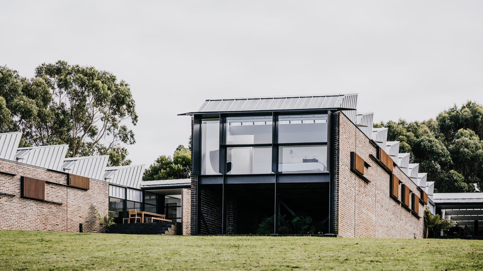A modern building with a glass facade, brick walls, and a flat roof.