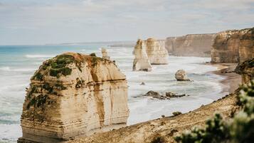Un paisaje costero con imponentes acantilados de piedra caliza y una playa.
