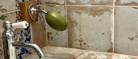 A bathroom with a sink, a mirror, and a shower area.