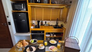A compact kitchen with a dining area, equipped with a microwave, coffee maker, and a sink. - Luxury loft with jacuzzi, Casinhas do morro. (Gamboa)