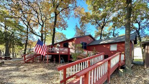 A rustic cabin with a wooden deck and a small porch.