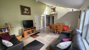 A living room with a TV, bookshelves, a sofa, and a dining area with chairs and a table. - In the heart of Durango (Durango)