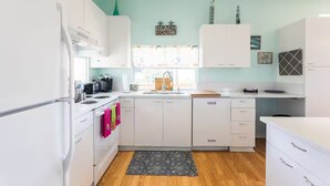 Una cocina moderna con armarios blancos, una encimera negra y un ventanal con vistas.
