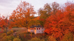 Een klein huis omgeven door herfstkleuren.