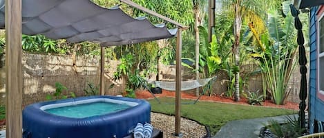Spacious backyard that's fully private and fenced in. Saluspa Hot Tub, Hammock, Mango Tree, Lush Mature Tropical Plants, String lights for Nighttime Relaxation, Outdoor Chairs.