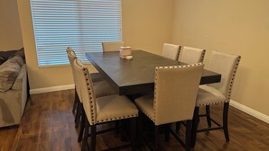 A dining room with a rectangular table and six upholstered chairs with button detailing.
