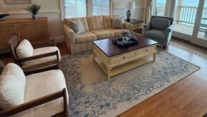 A living room with a sofa, chairs, a coffee table, and a ceiling fan. - NEW listing! Sail Away - Ocean front TOP floor condo in charming Rodanthe (Rodanthe)