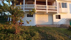 Una casa de dos pisos con balcón, garaje y una ventana pequeña.