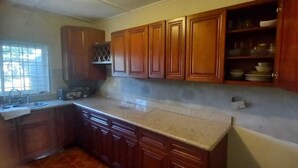 Una cocina con armarios de madera, una encimera y un ventanal.