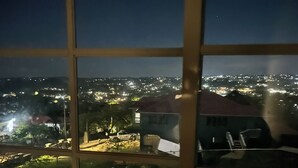 Vista nocturna a través de una ventana con un paisaje urbano de fondo.