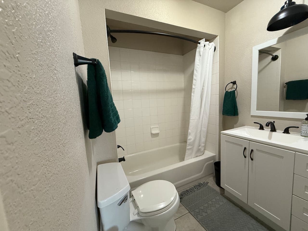 A bathroom with a bathtub, toilet, and sink.