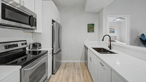 A modern kitchen with stainless steel appliances, white cabinetry, and a marble countertop. - Modern 2BR/2BA Retreat: Ground Floor / Pool, Spa, Gym / North Scottsdale Getaway (Scottsdale)