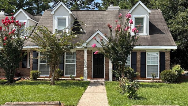 A two-story house with a brick facade, a front porch, and a pathway leading to the entrance. - Spacious double units dublex in Lawrenceville (Lawrenceville)