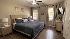 A bedroom with a bed, nightstands, a ceiling fan, a TV, and a wardrobe. - Spacious double units dublex in Lawrenceville (Lawrenceville)