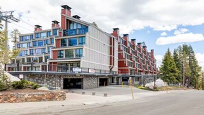 A multi-story hotel with a modern architectural design, featuring large windows and a stone facade.