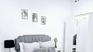 A neatly arranged bedroom with a bed, bedside tables, a wardrobe, and wall art. - ROMANTIC SUITE MAYDUNY (Tampa)