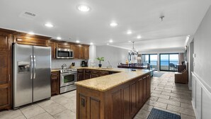 A spacious kitchen with wooden cabinets, stainless steel appliances, and a large island.