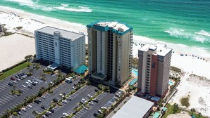 A hotel with a parking lot, a beach, and ocean views.