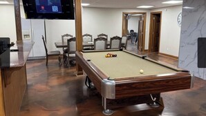 A pool table with a digital scoreboard in a room with wooden flooring and a marble wall. - Bedrooms for rent in a very nice space (Joplin)