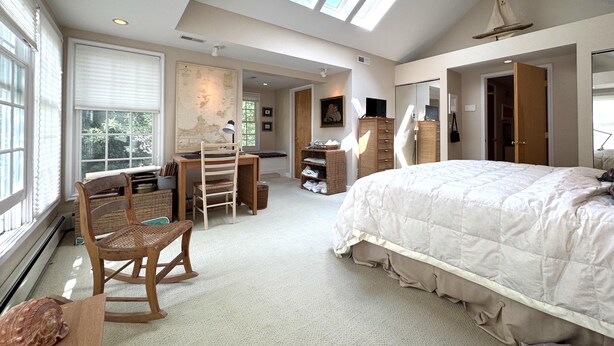 A bedroom with a large bed, a desk with a chair, a map on the wall, and skylights. - 328 Cherry Close Walk to Downtown and Pool (Lakeside)