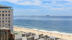 Una playa con edificios al frente y cielo despejado.