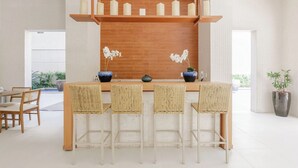 Una cocina moderna con una isla central, estantes de madera y velas decorativas.