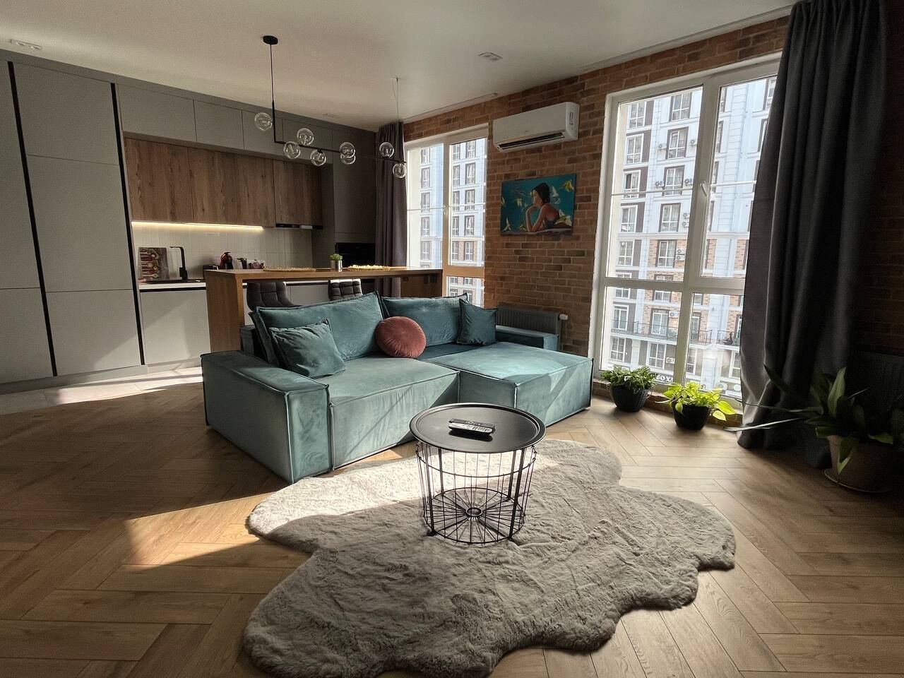 Un salon moderne avec un canapé, une table basse ronde et un tapis à longues mèches.