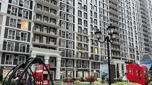 A multi-story building with balconies, a red double-decker bus, and a red telephone booth. - New England Ecoloft Studios (Kyiv)