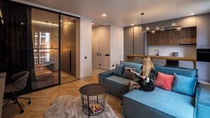 A modern living room with a sofa, a coffee table, and a glass partition. - New England Ecoloft Studios (Kyiv)