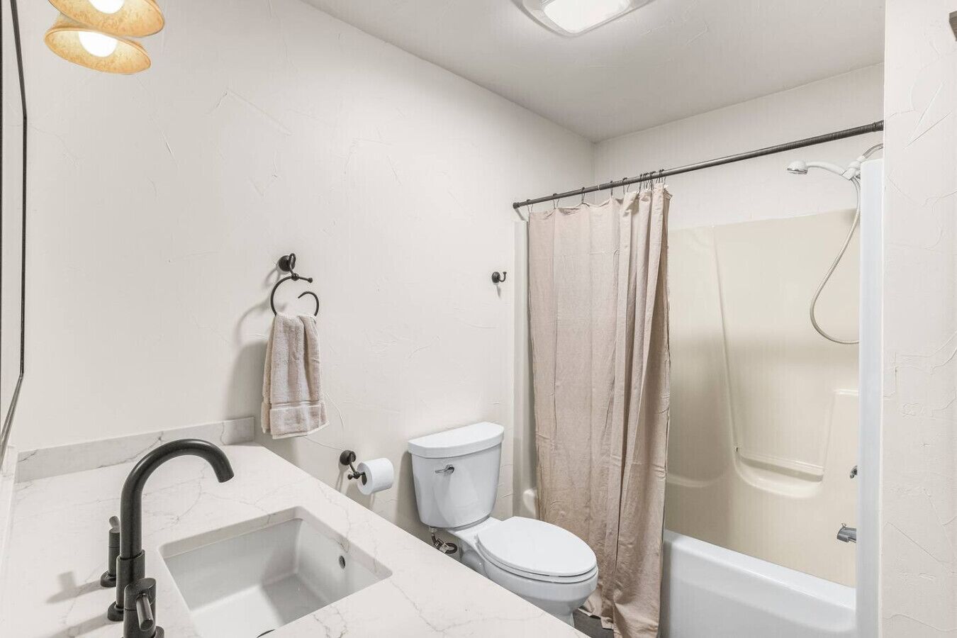 A bathroom with a sink, toilet, and shower.