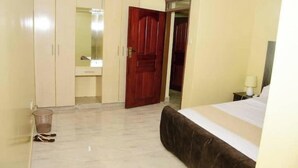 A bedroom with a bed, a wardrobe, and a mirror. - Majestic Furnished in Kitale@360 (Trans-Nzoia County)
