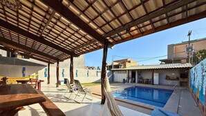 A covered outdoor area with a pool, a table, and chairs. - MHV Milagres - Casa Naru (Passo de Camaragibe)