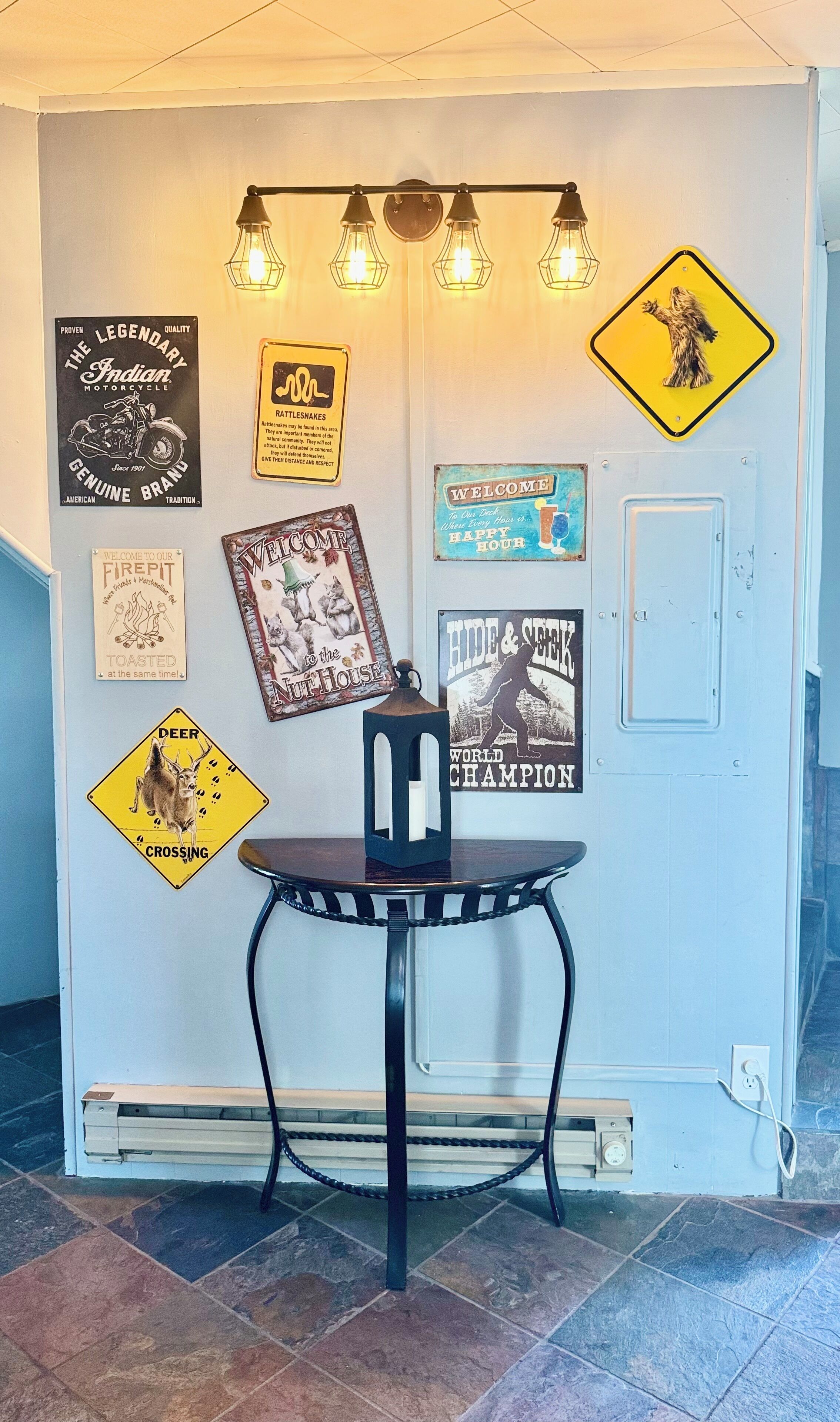 Pareda decorada com diversos sinais e uma mesa com um candeeiro.