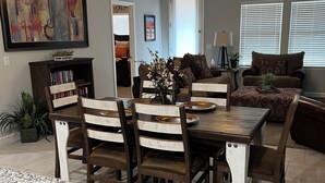 A dining area with a wooden table and chairs, a ceiling fan, and a painting on the wall. - Saguaro Bloom Beauty (Marana)