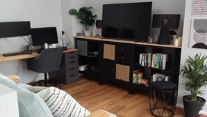 A modern living room with a sofa, a desk with a computer, a TV, and a bookshelf. - Luxury with a 2 min walk to beach! A new way to Rosebud (Rosebud)