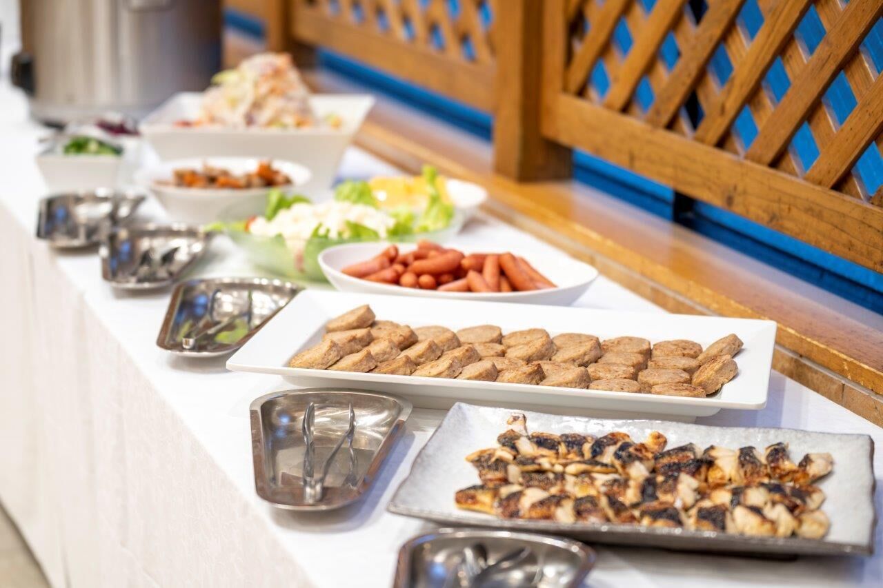 A buffet table with various food items including meats, vegetables, and salads.