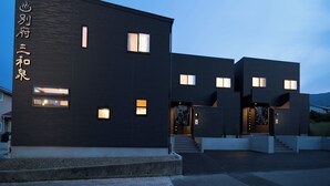 A modern building with a dark facade and multiple windows.