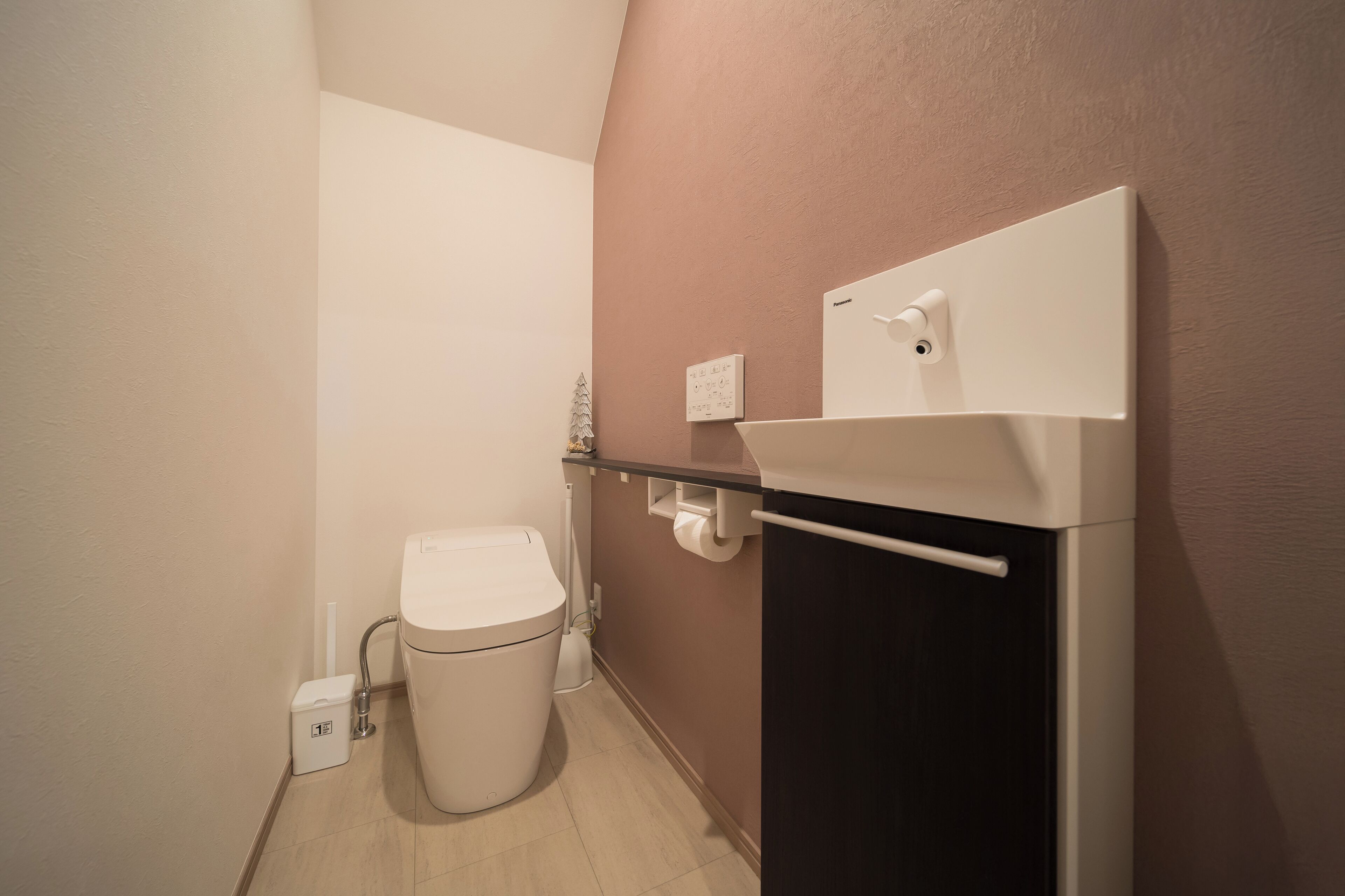 Ein kleines, modernes Badezimmer mit Toilette, Waschbecken und Handtuchhalter.