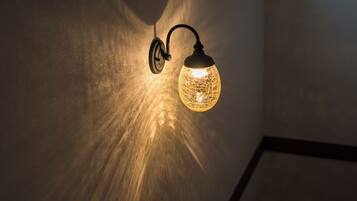 Un luminaire mural doté d’un abat-jour en verre sphérique.