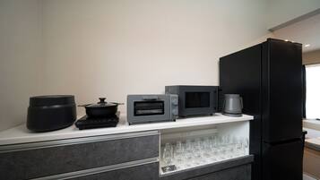 A modern kitchen with a black refrigerator, a microwave, a toaster, and a coffee maker on the countertop.