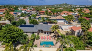 A residential area with houses, a swimming pool, and solar panels.
