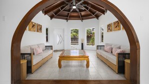 A cozy living room with a wooden coffee table, two sofas, and a large arched doorway.
