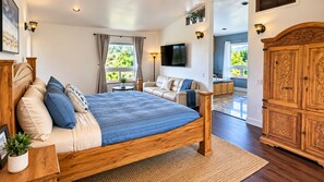 A bedroom with a wooden bed, a sofa, a TV, and a wardrobe.