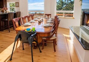 Sunny dining room with water views, fireplace, and family-friendly seating