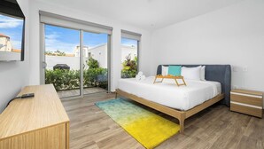 Une chambre à coucher moderne avec un lit, une table de chevet et un bureau.